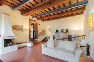 a living room with a white couch and a fireplace at Felciolina - Medieval Country House in Troghi