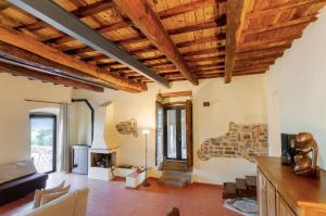 a living room with wooden ceilings and a fireplace at Felciolina - Medieval Country House in Troghi