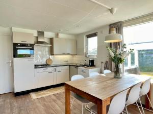 a kitchen with a wooden table and white cabinets at De Snip in Ballum +17 photos