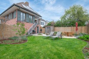 a backyard with a brick house with a wooden fence at Amazing villa for 8 in Bredene in Bredene