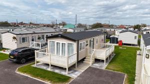 a house with a car parked in a parking lot at Hardys Caravan Park in Ingoldmells