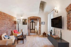 a living room with a brick wall and a tv at La Volta Segreta in Albenga