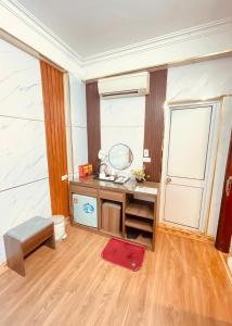 a bathroom with a vanity with a mirror and a red rug at Hà Thành Luxury Hotel in Hanoi