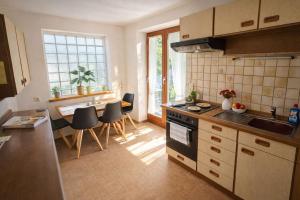 a kitchen with a sink and a table with chairs at SK Ferienapartments Kappelrodeck in Kappelrodeck