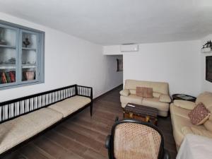 a living room with two couches and a table at Olive Mill Complex in Livadi +9 photos