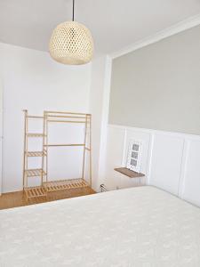 a room with a white bed and a light fixture at La Dama Boba in Olmedo