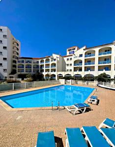 a swimming pool in front of a large building at Notre location au Barcarès in Le Barcarès
