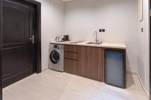 a kitchen with a sink and a washing machine at فندق لفيف العريض - Lafeef Hotel Al-Aridh in Medina