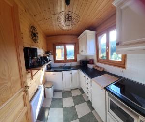 a kitchen with white cabinets and black counter tops at Chalet Les Vosgiennes in Le Valtin