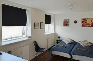 a bedroom with a bed and a chair and a window at H&M Homes Apartments in Aarhus