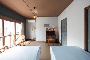 a bedroom with two beds and a desk and a window at KARASUYA GuestHouse in Takasaki +90 photos