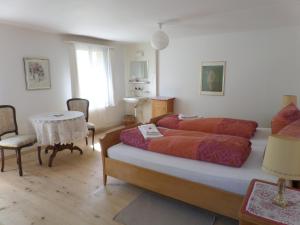 a bedroom with a large bed and a table at Hotel Rigi Klösterli in Rigi Klösterli