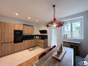 a living room with a dining table and a kitchen at Maison du Caboteur de La Baule, Centre & plage à pied, Patio cosy, 8 pers in Le Pouliguen