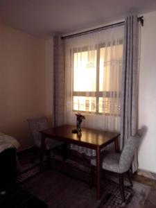 a room with a table and chairs and a window at Raah residence in Nairobi +19 photos