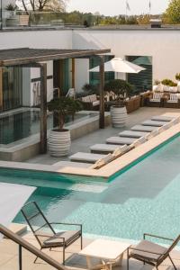 a pool at a hotel with chairs and umbrellas at Sankt Jörgen Park in Gothenburg