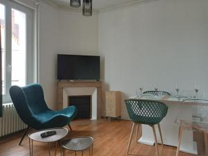 a living room with two chairs and a television at Appartement de cachet de 63m2 in Moulins