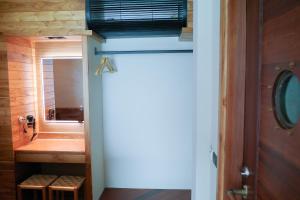 a bathroom with a mirror and a wooden door at Salty Pearl Beach Front Phuket 3 in Patong Beach +15 photos