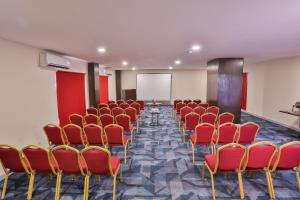 a conference room with red chairs and a whiteboard at Avari Boutique Gujranwala in Fattu Mand