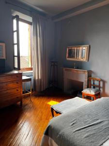 a bedroom with a bed and a desk and a window at Locanda Orticello in Monferrato in Cremolino
