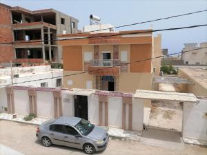a small car parked in front of a building at Beach lodge in Chebba