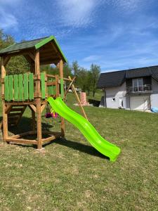 a playground with a green slide and a gazebo at Apartman-vikendica Mihajlović in Banja Luka