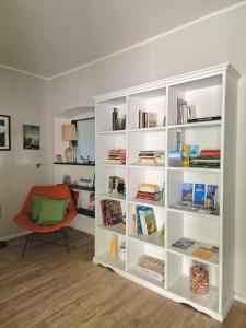 a white book shelf with books and a chair at Villa Cangallo in Chiavari