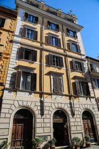 um edifício amarelo alto com janelas e portas em Residenza Maritti ContemporarySuite em Roma