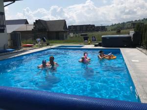 a group of people sitting in a swimming pool at Basen z podgrzewaną wodą jacuzzi dmuchaniec sala zabaw WSZYSTKO W CENIE POBYTU in Białka Tatrzańska