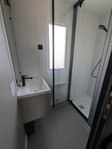 a bathroom with a sink and a shower at Camping de Lanven in Plomeur +21 photos