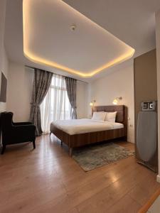 a bedroom with a large bed and a chair at Zemilo Hotel Apartment in Addis Ababa +28 photos
