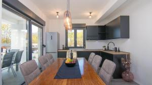 a kitchen and dining room with a table and chairs at Villa Dani by Villas Guide in Gostinjac