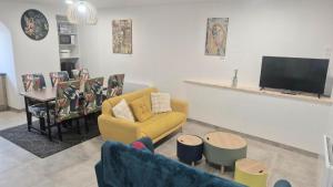 a living room with a yellow couch and a tv at La Traboule - Terrasse - 6 pers in Saint-Germain-Lembron