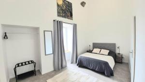 a white bedroom with a bed and a window at La Traboule - Terrasse - 6 pers in Saint-Germain-Lembron