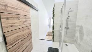 a bathroom with a shower with a wooden wall at La Traboule - Terrasse - 6 pers in Saint-Germain-Lembron +22 photos