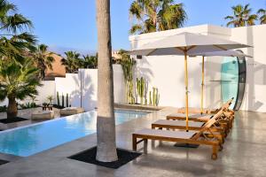 a group of lounge chairs and an umbrella next to a swimming pool at Casa Alisios Sea View Villa private Infinity Pool Sunsets in La Pared +17 photos