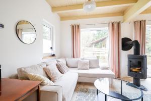 a living room with a white couch and a fireplace at Murawki Dom Blisko Jeziora in Urowo