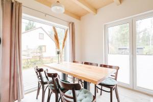 a dining room with a table and chairs and a large window at Murawki Dom Blisko Jeziora in Urowo +33 photos