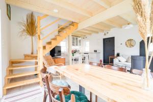 a kitchen and living room with a wooden table and stairs at Murawki Dom Blisko Jeziora in Urowo