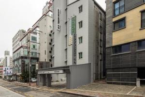 a building on a city street with tall buildings at Anook Hotel Suwon Ingye 2 in Suwon