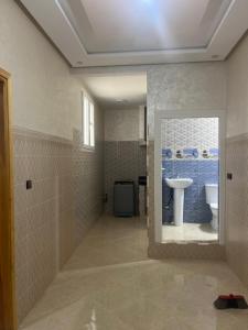 a bathroom with a sink and a mirror and a toilet at Rachid in Oulad Akkou