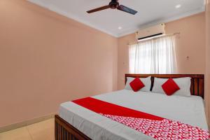 a bedroom with a bed and a ceiling fan at Hotel O RD CONVENTIONS in Visakhapatnam