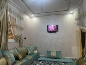 a living room with a couch and a flat screen tv at Rachid in Oulad Akkou