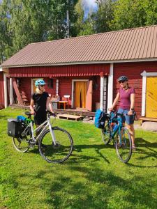 two women standing with their bikes in front of a cabin at Reittiö B&B in Sulkava