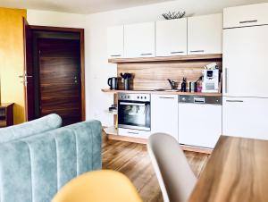 a kitchen with white cabinets and blue chairs in a room at Haus Leitner in Attersee am Attersee