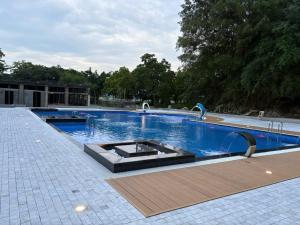 a large swimming pool with blue water at The Palm Tree Bungalow in Xuân Sơn