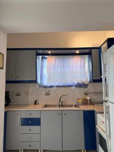 a kitchen with a sink and a window at Pelekanos Apartment in Paralia Saranti +19 photos