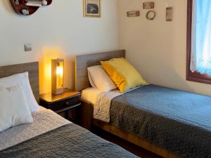 a bedroom with two beds and a lamp on a night stand at Lithos House in Monólithos +43 photos