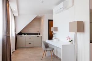 a kitchen with a white counter and a chair at Hotel Grand Asia in Walferdange