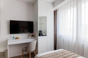 a bedroom with a bed and a tv on a wall at Hotel Grand Asia in Walferdange +16 photos