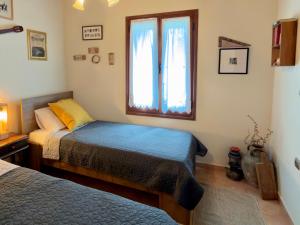 a bedroom with two beds and a window at Lithos House in Monólithos